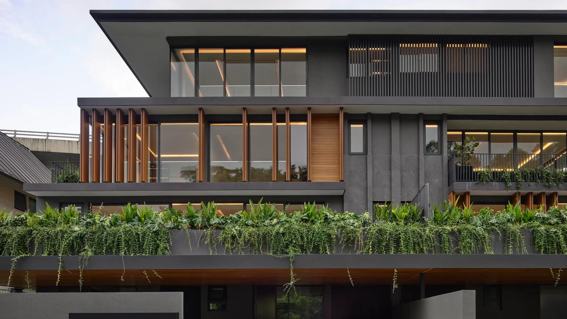 The Tembusu House from the street, its planted ledge running the width of the elevation.