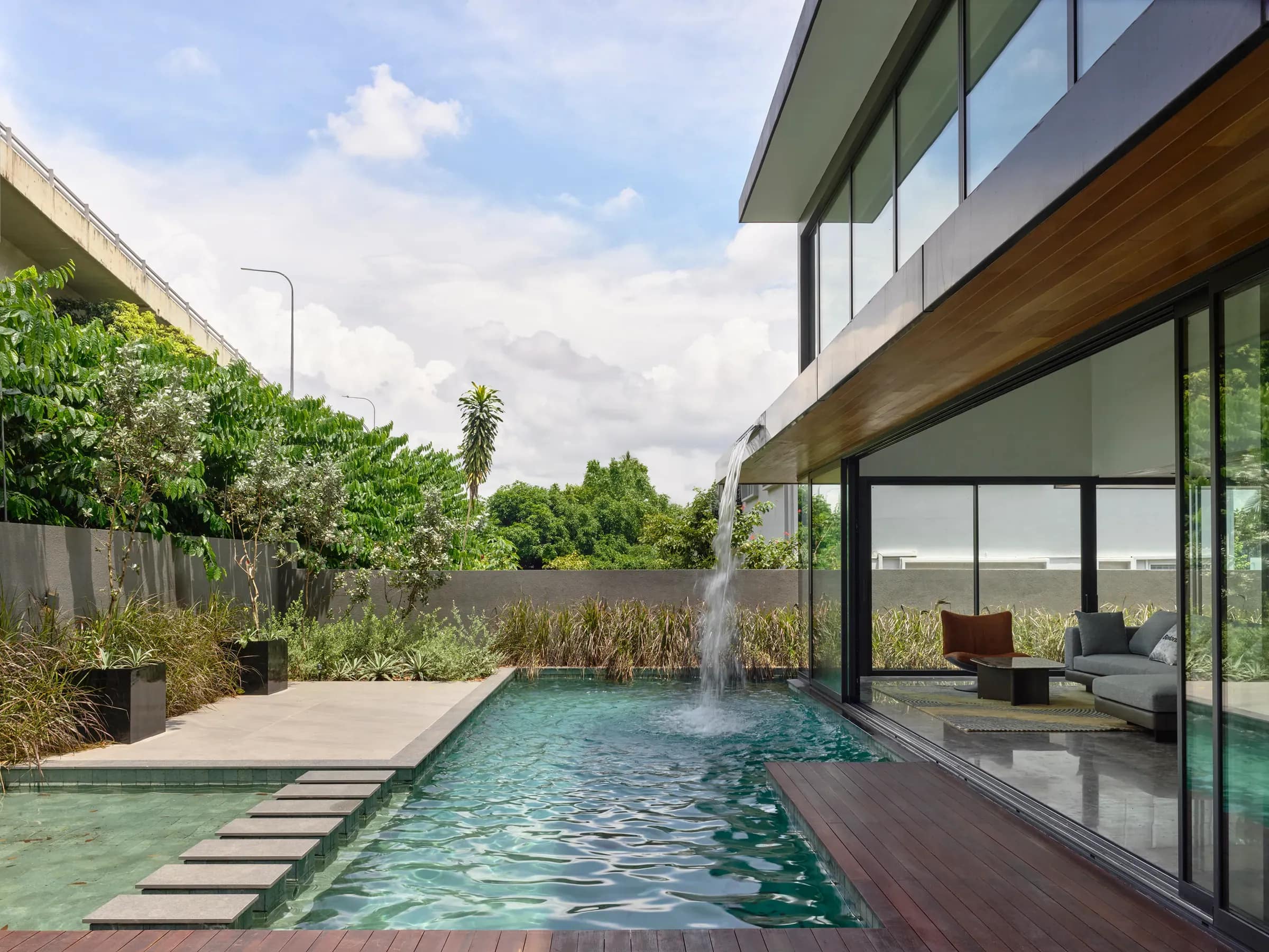 Planting along the pool edge at The Caspian House, the living level open to the garden.